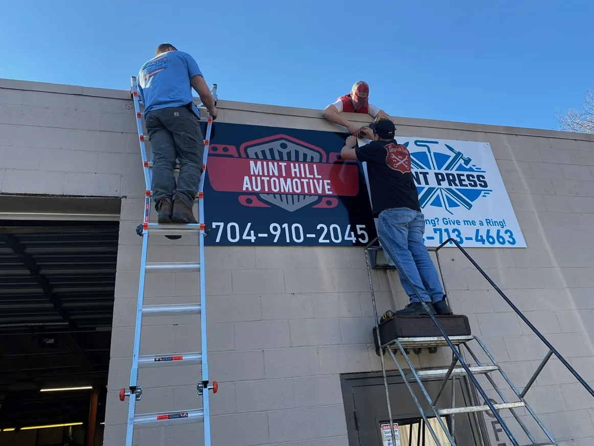 Installing the Mint Hill Automotive sign on storefront in Mint Hill NC